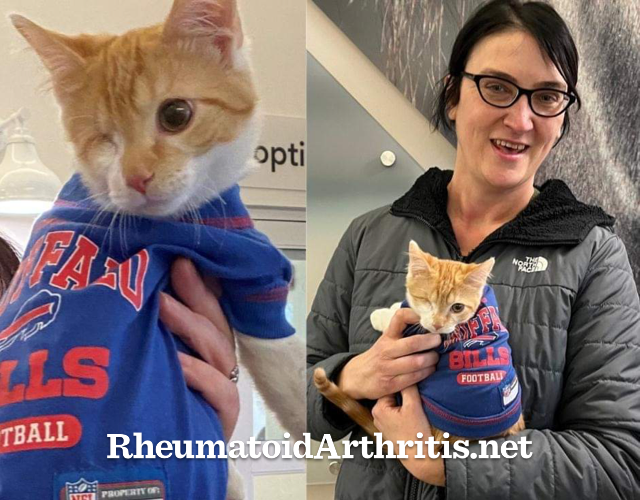 RA patient leader Lynn Marie Witt smiles, holding a one-eyed orange kitten.